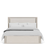 Beige upholstered bed with white bedding on a white background