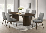 Dining room with a dark wooden oval table and gray chairs on a light wood floor.