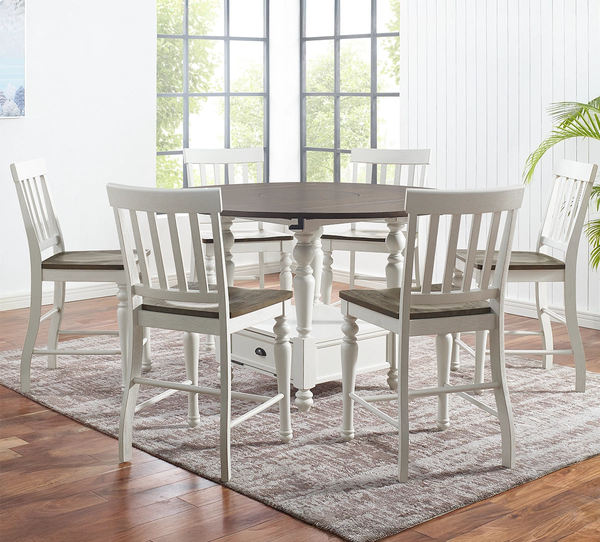 Dining room with a round table and six chairs on a wooden floor.