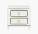 White nightstand with decorative trim and two drawers on a white background